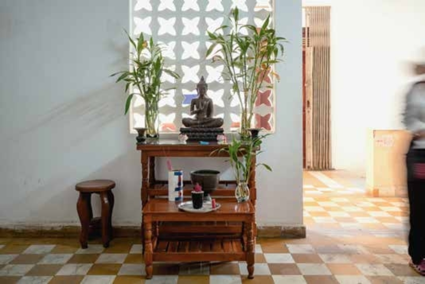 Innenansicht des Tuol Sleng Museums: kleines Regal, Pflanzen, Hocker