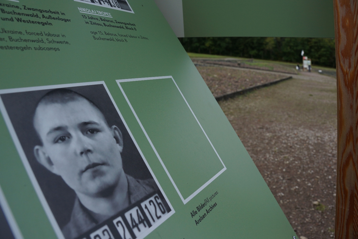 Detail der Outdoor-Ausstellung: Auf der Tafel ist das Foto eines Verhafteten zu sehen.