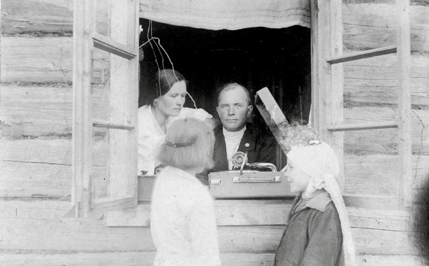 Schwarz-Weiß-Fotografie von Lewschenkow, er selbst blickt aus dem Fenster, vor ihm steht ein Grammophon
