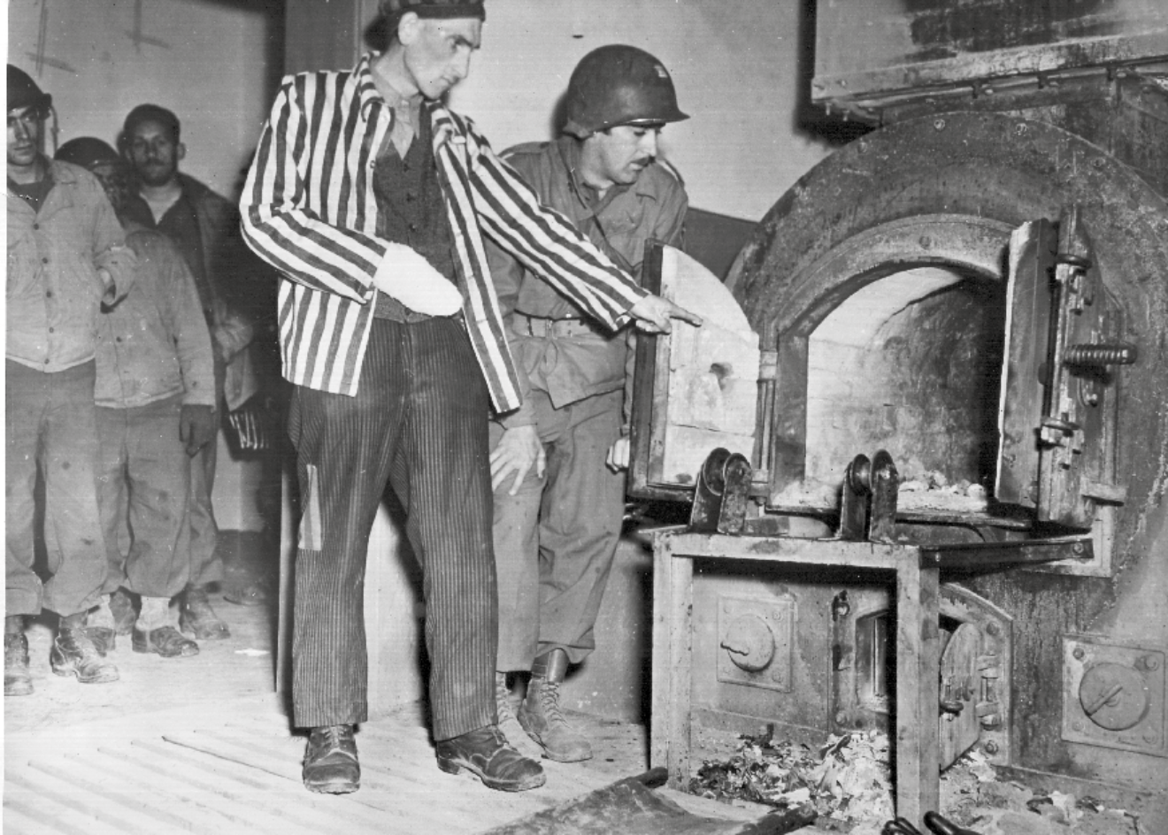 Ein polnischer KZ-Überlebender zeigt einem Soldaten der US-Armee den Krematoriumsofen im befreiten KZ Mittelbau-Dora
