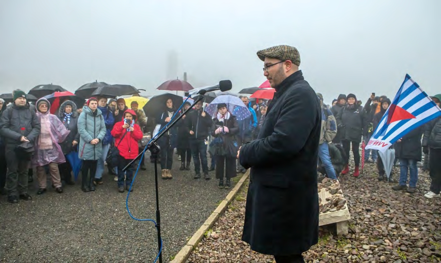 Christoph Tümpßer spricht vor Menschenmenge auf dem Lagergelände Buchenwalds