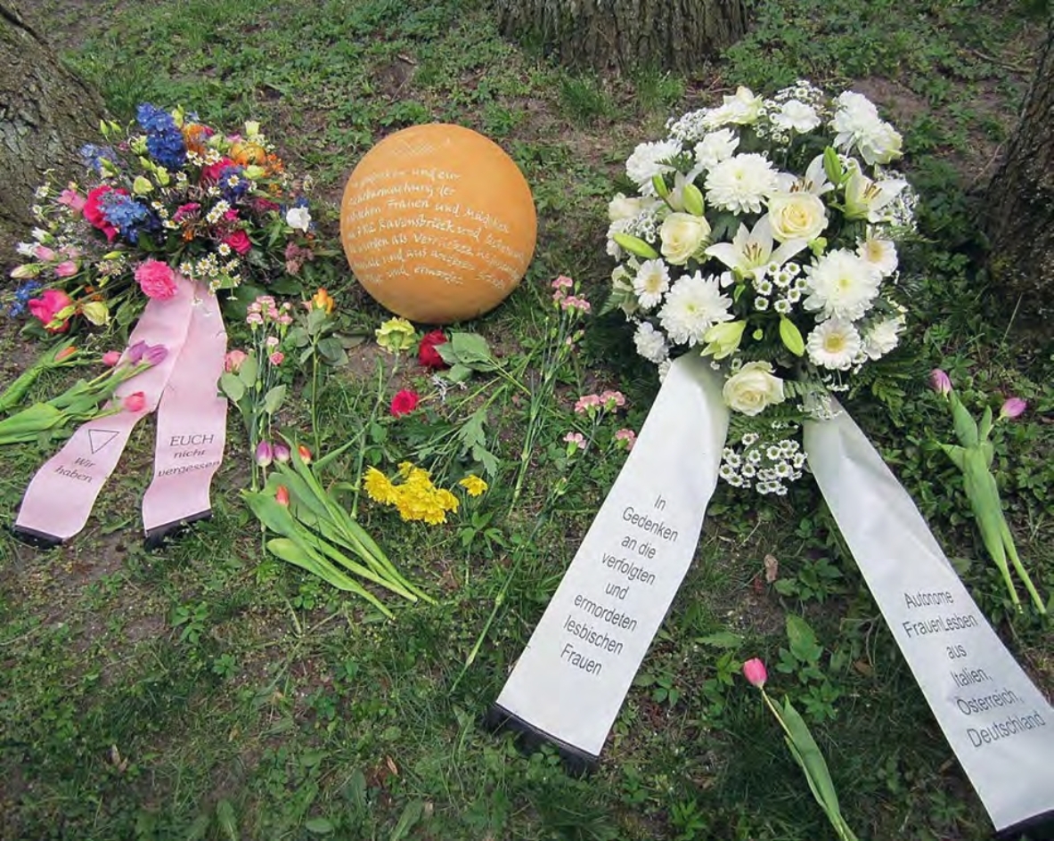 Kränze und beschriftete Kugel zum Gedenken an lesbische KZ-Häftlinge in Ravensbrück