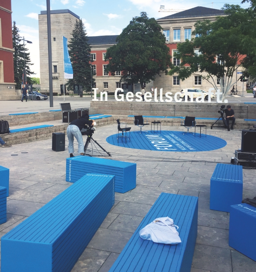 Gestaltung des Formats "In Gesellschaft": blaue Bänke und Aufsteller