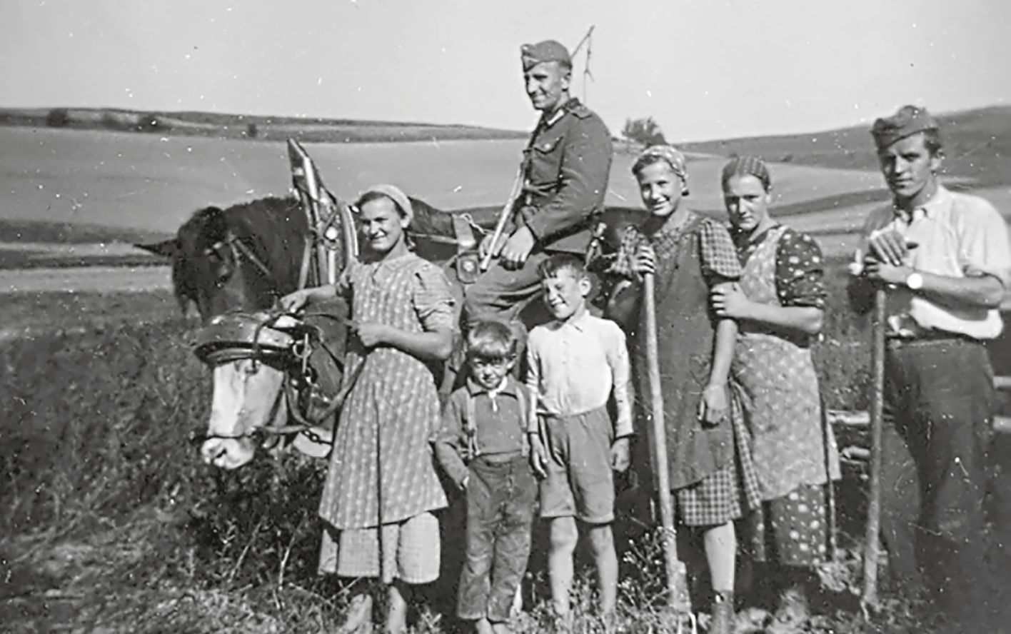 Einheimische Landarbeiterinnen, ein deutscher Soldat und ein französischer Kriegsgefangener gemeinsam auf einem Bild