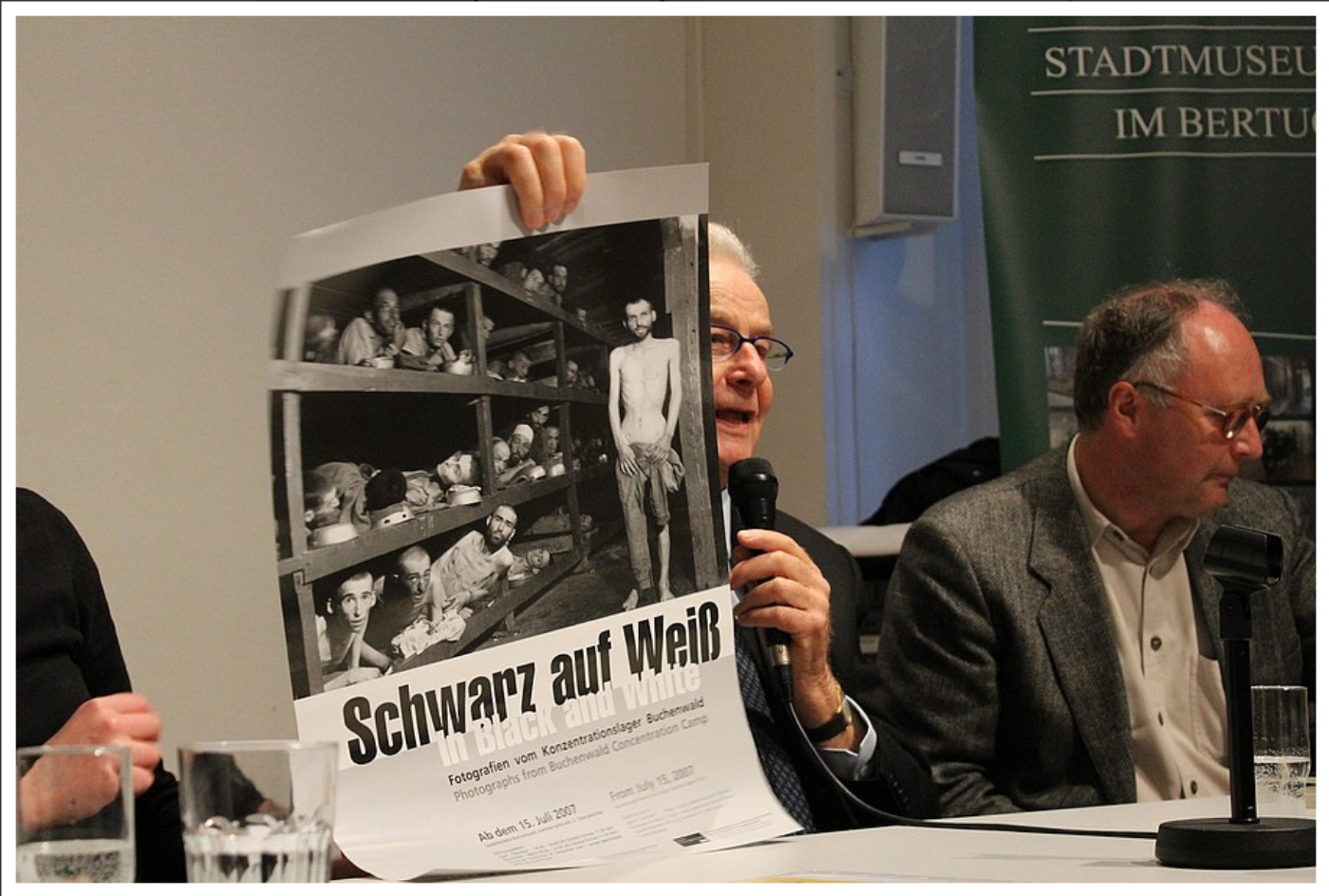 Der Holocaustüberlebende Naftali Fürst hält bei einem Zeitzeugengespräch ein Plakat hoch.