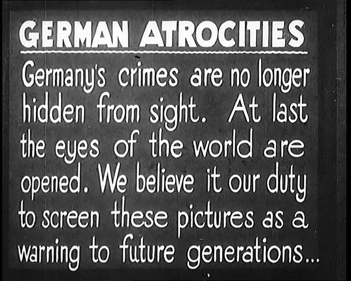 Eine historische Schwarz-Weiß-Tafel mit der Überschrift „GERMAN ATROCITIES“ (deutsch: „Deutsche Gräueltaten“). Darunter steht in englischer Sprache der Text: „Germany’s crimes are no longer hidden from sight. At last the eyes of the world are opened. We believe it our duty to screen these pictures as a warning to future generations...“ (Dt.: „Deutschlands Verbrechen sind nicht länger verborgen. Endlich sind die Augen der Welt geöffnet. Wir sehen es als unsere Pflicht, diese Bilder als Warnung für zukünftige Generationen zu zeigen...“).