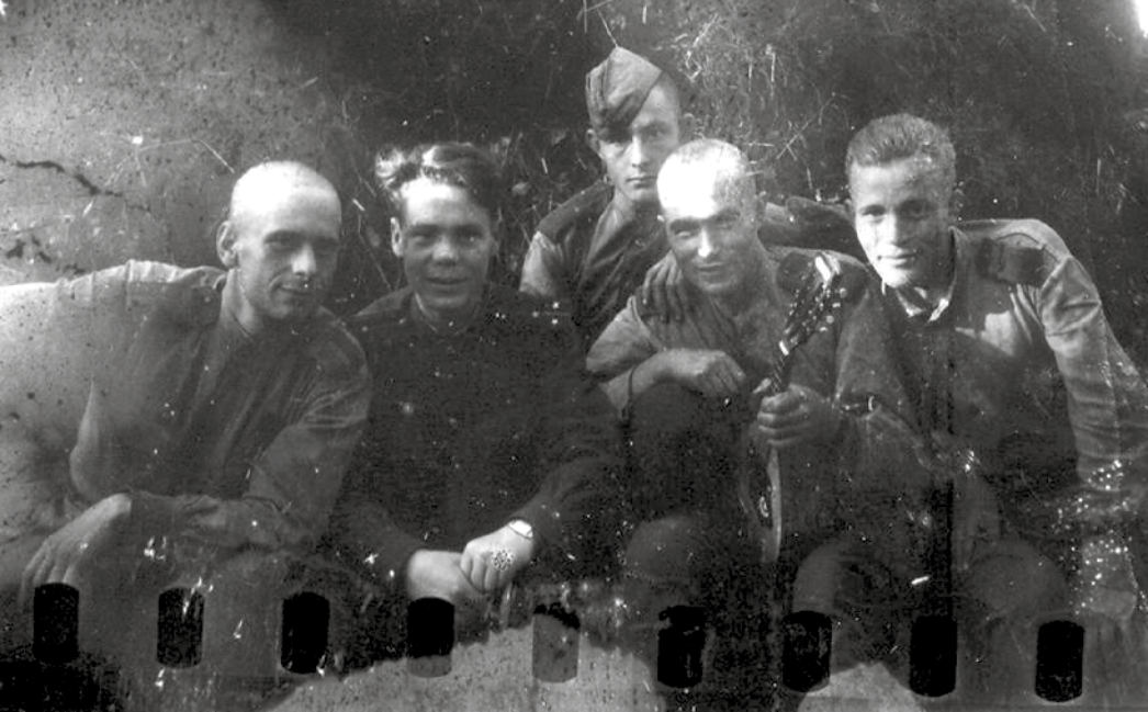 Schwarz-Weiß-Fotografie von mehreren Soldaten der Roten Armee, darunter Lewschenkow in der Mitte mit Mandoline.