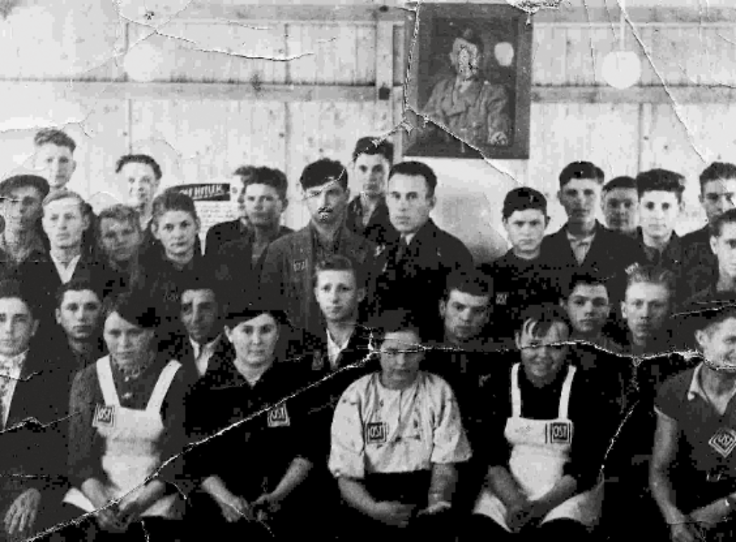 Gruppe junger Zwangsarbeiter:innen aus der Sowjetunion, gekennzeichnet durch "OST"-Abzeichen