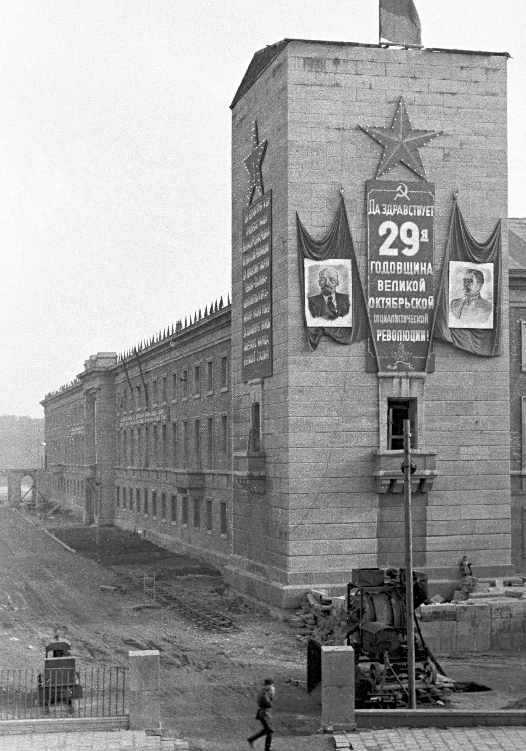 Schwarz-Weiß-Foto des Turms des ehemaligen Gauforums, festlich geschmückt mit Bildern von Stalin und Lenin
