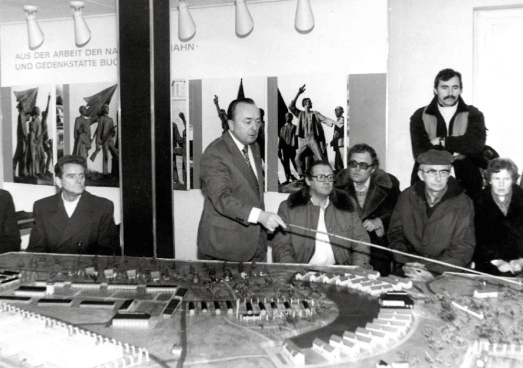Schwarz-Weiß-Foto: Rothmann zeigt und erklärt Gästen das Modell von Buchenwald