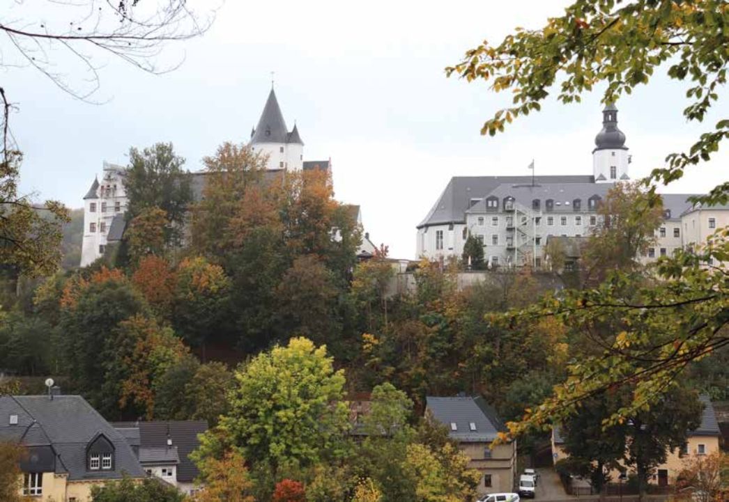 Stadtbild: Bäume, dahinter das Schloss Schwarzenberg und die St.-Georgen-Kirche