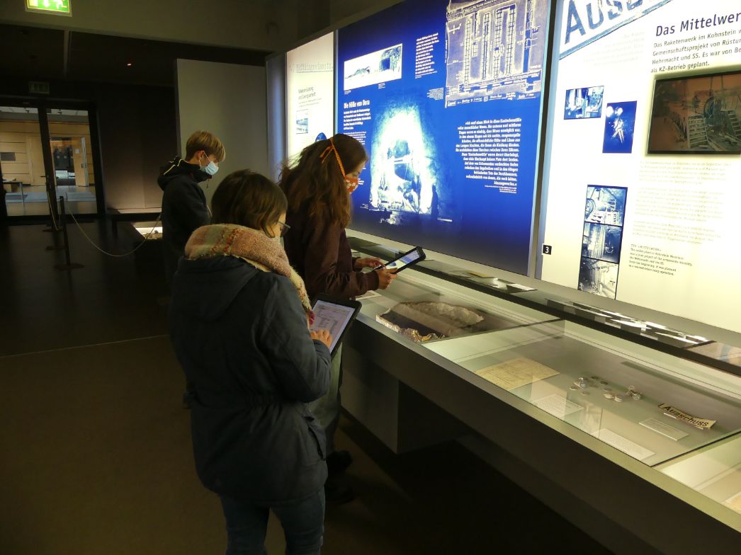 Besucher:innen der Ausstellung mit Tablets