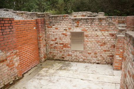 View of the information board at the entrance to the Dietrich Bonhoeffer Memorial. The remains of the wall are made of red brick