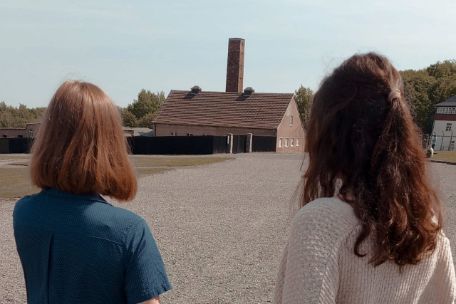 Zwei Freiwillige blicken über den ehemaligen Appellplatz in der Gedenkstätte Buchenwald