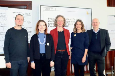 Das Ausstellungsteam steht vor einer elektronischen Tafel und einem Flip-Chart. Von links nach rechts sind folgende Personeen zu sehen: Vladislav Drilenko, Dr. Iryna Kashtalian, Kustodin Dr. Julia Landau, Dr. Anne-Christine Hamel und Christian Ernst Otto