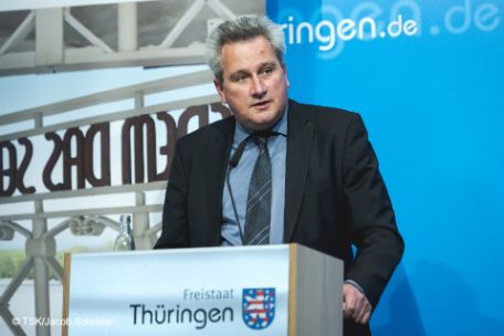 Jens-Christian Wagner standing behind a lectern with the inscription "Freistaat Thüringen".