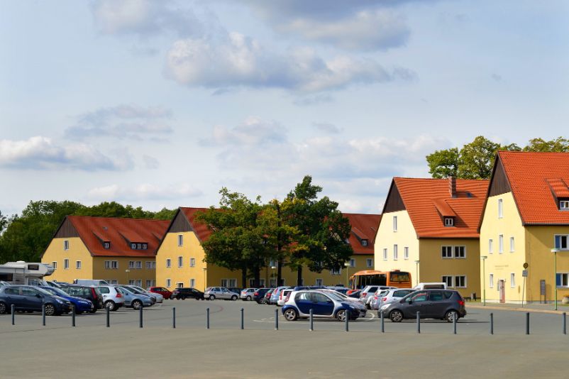 View of the parking lot of the memorial. Next to it the former SS barracks buildings, which are now used by the memorial. 